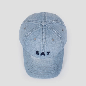 Close-up of EAT embroidery on washed denim baseball cap with premium texture and stitching