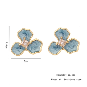 Detailed macro of enamel flower stud earring with blue marble texture and gold edges
