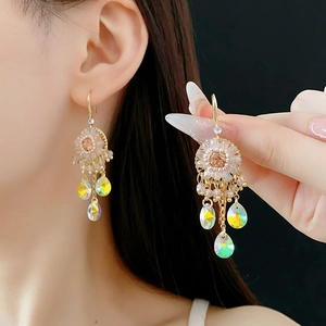 Detail of ethnic drop earrings featuring golden flowers and colorful crystal tassels