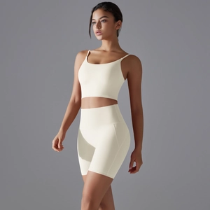 Dettaglio del set pantaloncini yoga e reggiseno sportivo in tessuto bianco crema