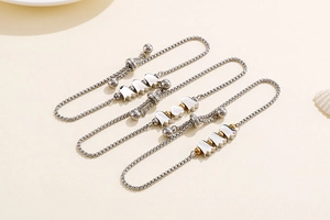 Detail of adjustable silver tulip bracelet set with delicate golden beads on a box chain