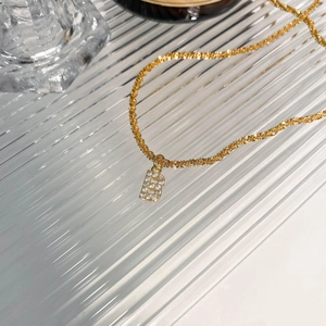Vue détaillée du pendentif lettre B doré avec oxydes de zirconium sur chaîne torsadée