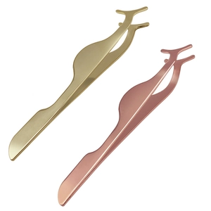 Detail view of gold and rose gold magnetic eyelash tweezers with ergonomic metal curves