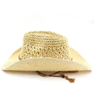 Close-up of beige straw cowboy hat with woven textures, brown decorative cord and wooden bead
