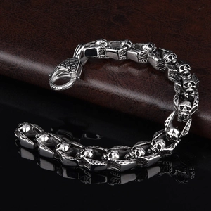 Close-up of vintage stainless steel skull link bracelet with lobster clasp on leather