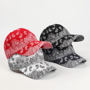Detailed pile of paisley baseball caps in red, white, black, and navy cotton canvas