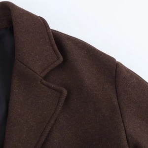 Détail du revers large et des coutures d'épaule d'un manteau marron en laine