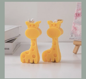 Detailed view of yellow giraffe-shaped scented candles set against a minimal white background
