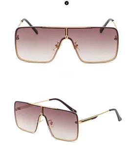 Detail view of large square metal sunglasses featuring gold frames and gradient lenses