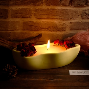 Bandeja de cerámica en forma de corazón con rosas secas sobre una mesa de madera