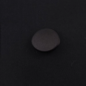 Makro-Detail des eleganten schwarzen Satinstoffs mit passenden bezogenen Knöpfen