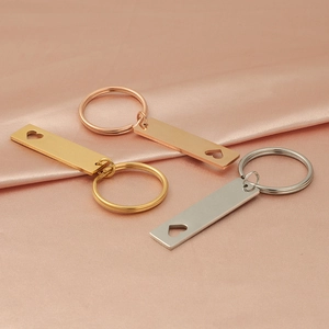 Three hollow heart rectangle keychains in gold, rose gold, and silver on silk fabric