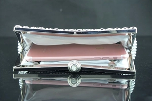 Detailansicht der weißen Perlen-Abendtasche mit Metallrahmen und Platz für ein Smartphone