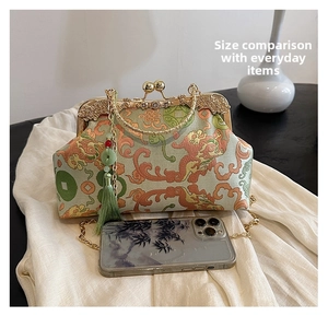 Detailed view of vintage brocade handbag with traditional pattern and metal chain