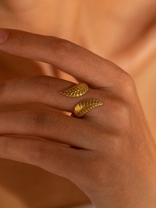 Detail of vintage gold-plated open ring showing delicate leaf vein textures on the band