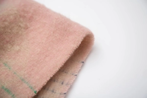 Detailed texture of pink loop yarn scarf featuring jacquard ginkgo leaf patterns