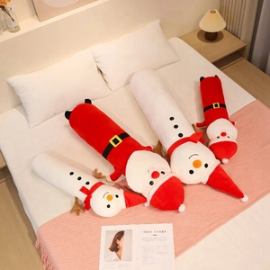 Detailed view of long Santa and snowman plush pillows arranged on a cozy white bed