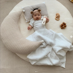 Quilted cotton moon-shaped nursing pillow with decorative pom-poms for newborn baby bedding