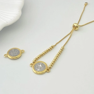 Macro detail of adjustable gold bead chain and Saint Benedict religious medal pendant