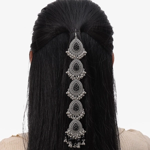 Close-up of vintage silver head chain with teardrop pendants on long black hair