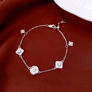 Vue détaillée du bracelet fleur en argent avec zircon et nacre sur soie rouge