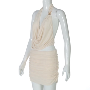 Detail of beige halter top with gold metal buckle and matching pleated mini skirt