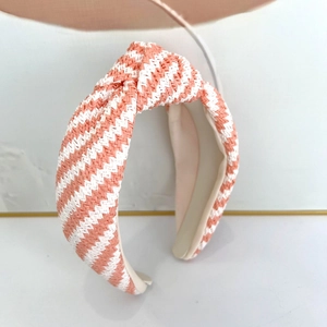 Détail du serre-tête tressé rose et blanc montrant le motif de tissage texturé en zigzag