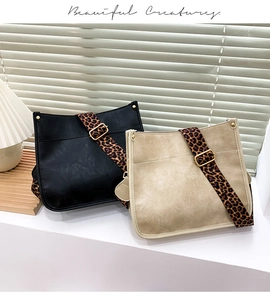 Detail of PU leather tote bags with wide leopard print knit straps and gold buckles