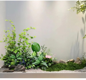 Detailed view of artificial moss lawn with realistic green ferns, pink flowers and stones