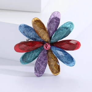 Detail of a colorful acrylic flower brooch with resin petals and pink crystal center
