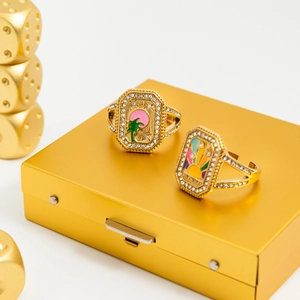 Détails de bagues dorées avec émail palmier soleil et strass brillants étincelants