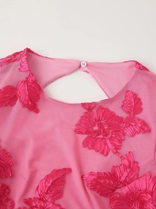 Détail de la robe rose en tulle avec broderies florales 3D et fermeture boutonnée