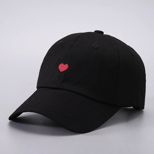Close-up of a black cotton baseball cap with detailed red heart embroidery on the front