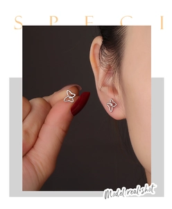 Detail view of s925 silver hollow butterfly earrings on model showing scale and shine