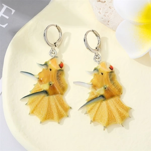 Detail of yellow triceratops dinosaur charm earrings with silver metallic hoops