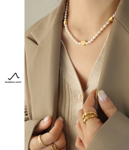 Detailed macro view of heart pendant necklace and gold rings made of stainless steel