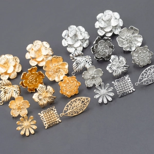Macro shot of 18k gold plated flower and leaf metal jewelry charms in gold and silver