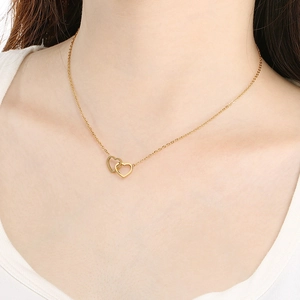 Minimalist 18K gold plated interlocking heart pendant necklace on female model neck