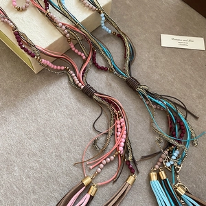 Detail of bohemian multilayer acrylic crystal necklace with long leather tassels