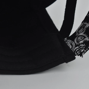 Close-up of black baseball cap featuring paisley pattern ribbon and durable stitching