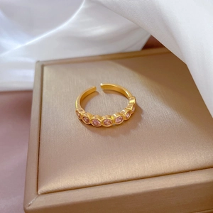 Macro detail of adjustable gold ring with seven pink round-cut zircon stones