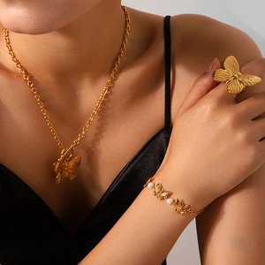 Gros plan sur l'ensemble de bijoux papillon dorés avec collier et bracelet perles
