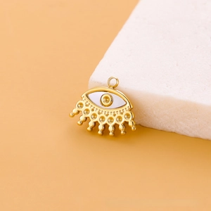 Vue macro d'un pendentif Mauvais Œil doré aux accents bohèmes sur une pierre blanche