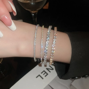 Detail shot of multi-layered tennis bracelets featuring sparkling zircon stones on a wrist
