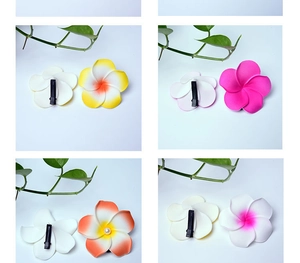 Detail of colorful plumeria flower hair clips with metal duckbill clips on white background