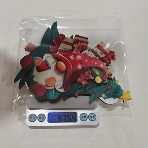Detailed view showing the set of wooden Christmas ornaments on a scale for weight check