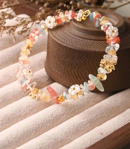 Macro detail of natural rainbow crystal stone bracelet with white flower charms