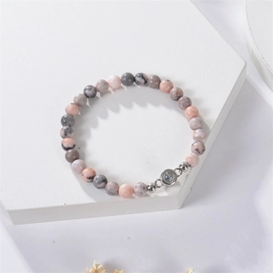 Detail of beaded bracelet with projection stone on white geometric pedestal