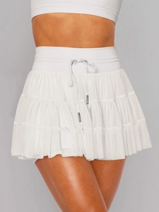 Detail of white layered mesh skort with elastic waistband and metallic drawstring tips