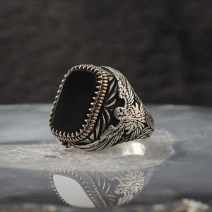 Detailed relief of an eagle and black gemstone on a vintage men's adjustable copper ring